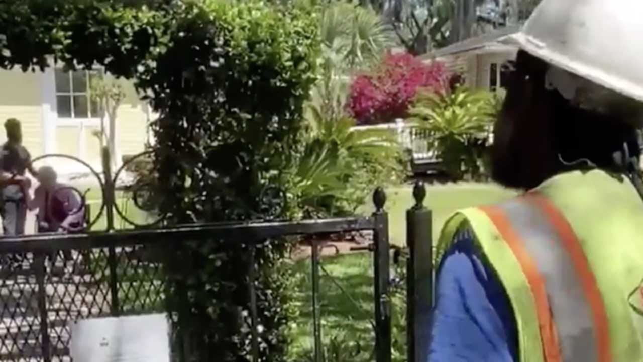 Utility Worker Gives Impromptu Performance To Elderly Woman Sitting Outside Senior Living Facility